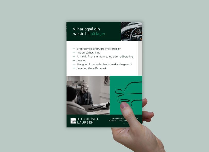 Hånd der holder flyer for autohuset laursen